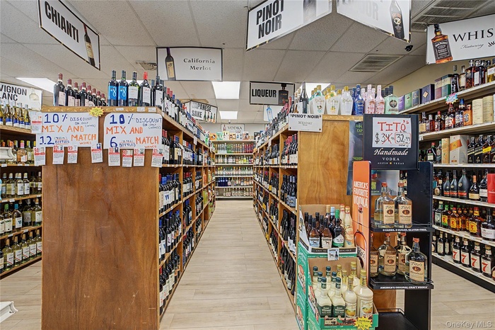Extensive retail space featuring multiple rows of product shelving, ceiling-mounted signage, and overhead fluorescent lighting