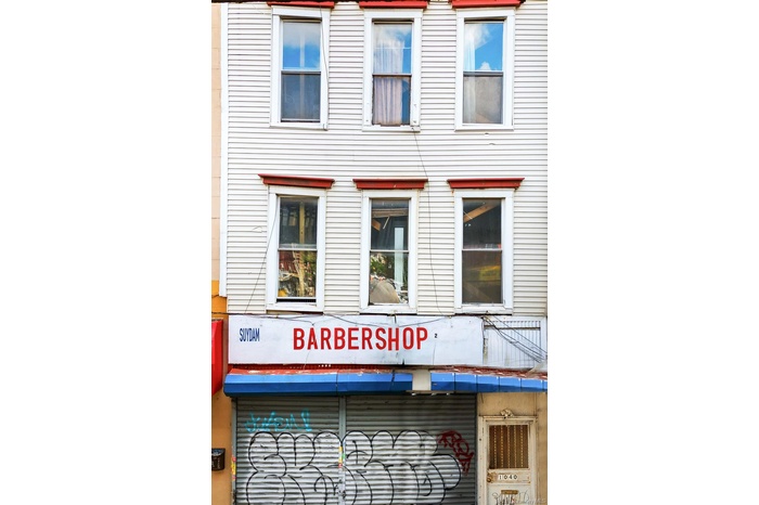 Three-story commercial building featuring vertical siding and multiple window units