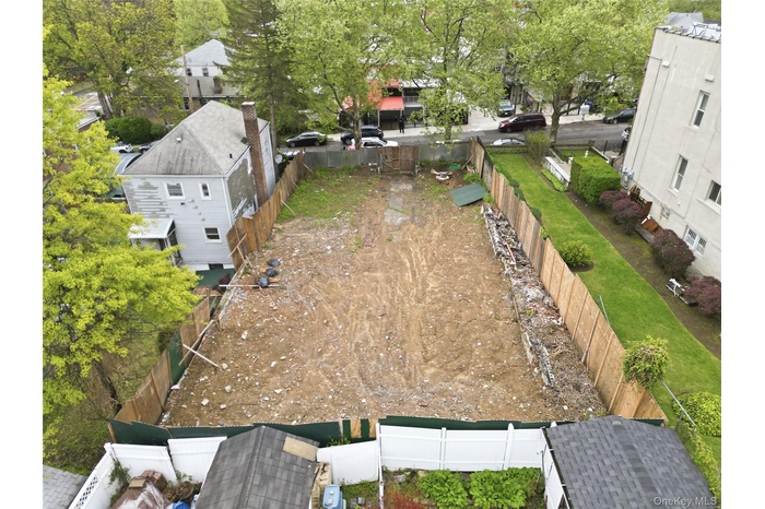 Spacious cleared lot featuring privacy fencing and surrounding mature trees