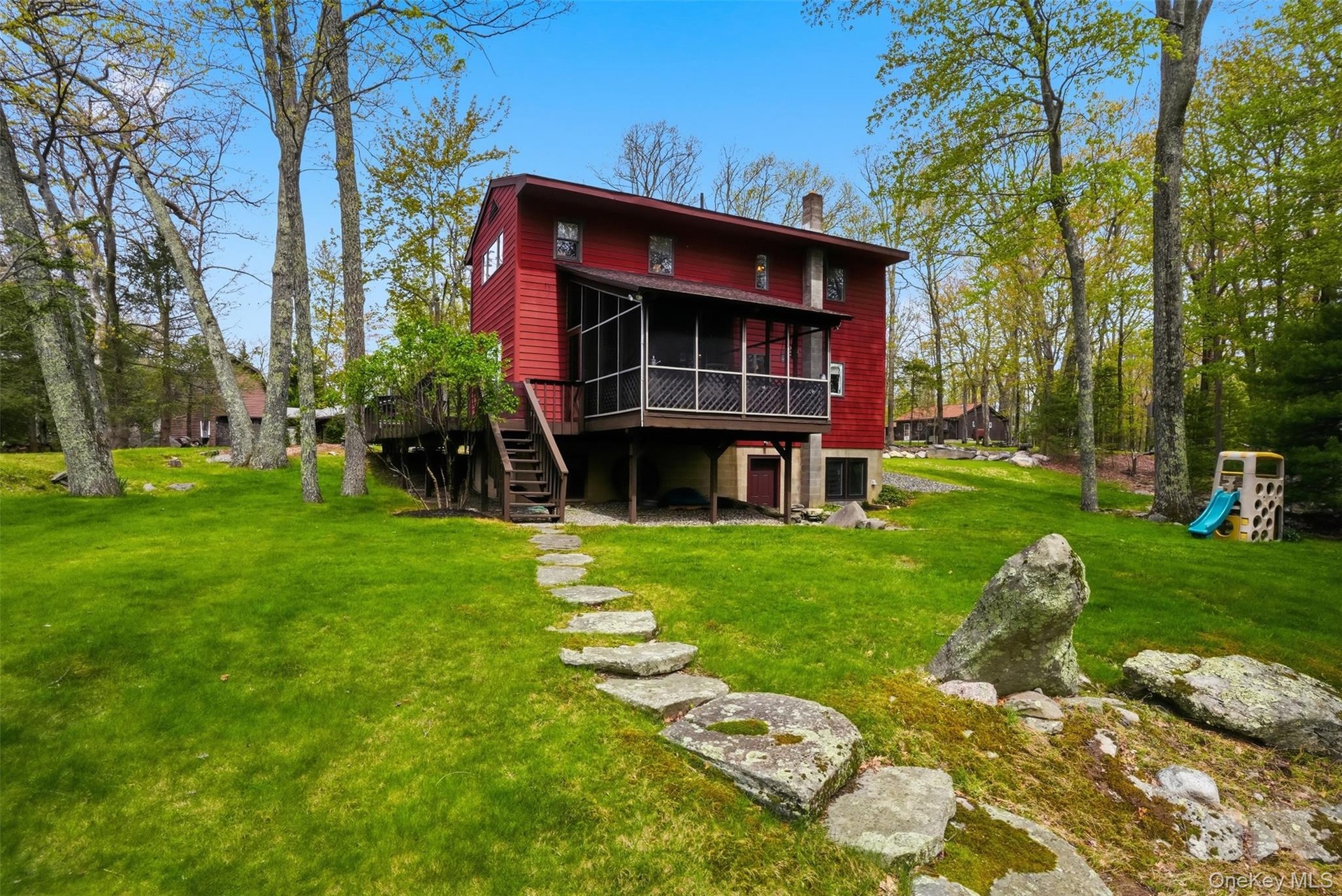 View of expansive green lawn and screened in porch.