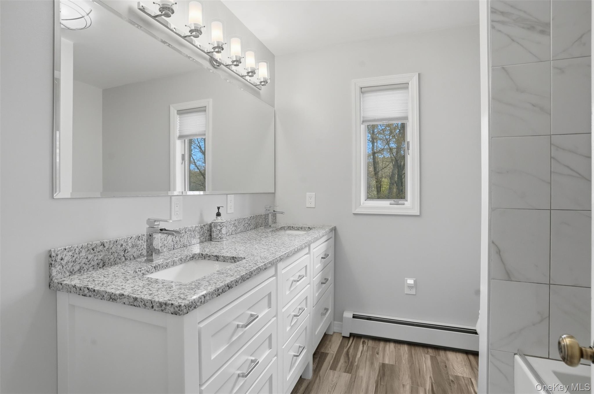 Upper-level 2nd bathroom. Double Sinks. Granite CT. tub/Shower. Tiled floors.