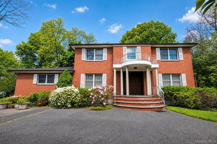 Brick exterior residence featuring white window shutters and a prominent front entry