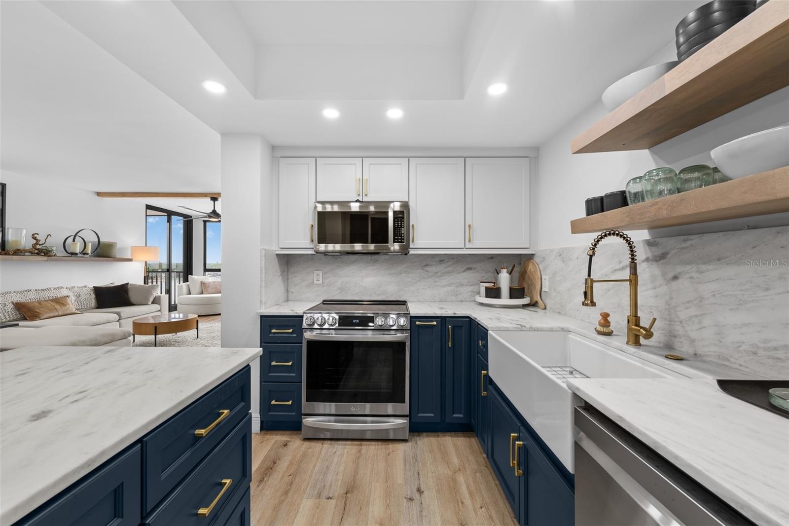 Cooking zone with LG induction range, marble backsplash, brass pull-down faucet, and open wood shelving.