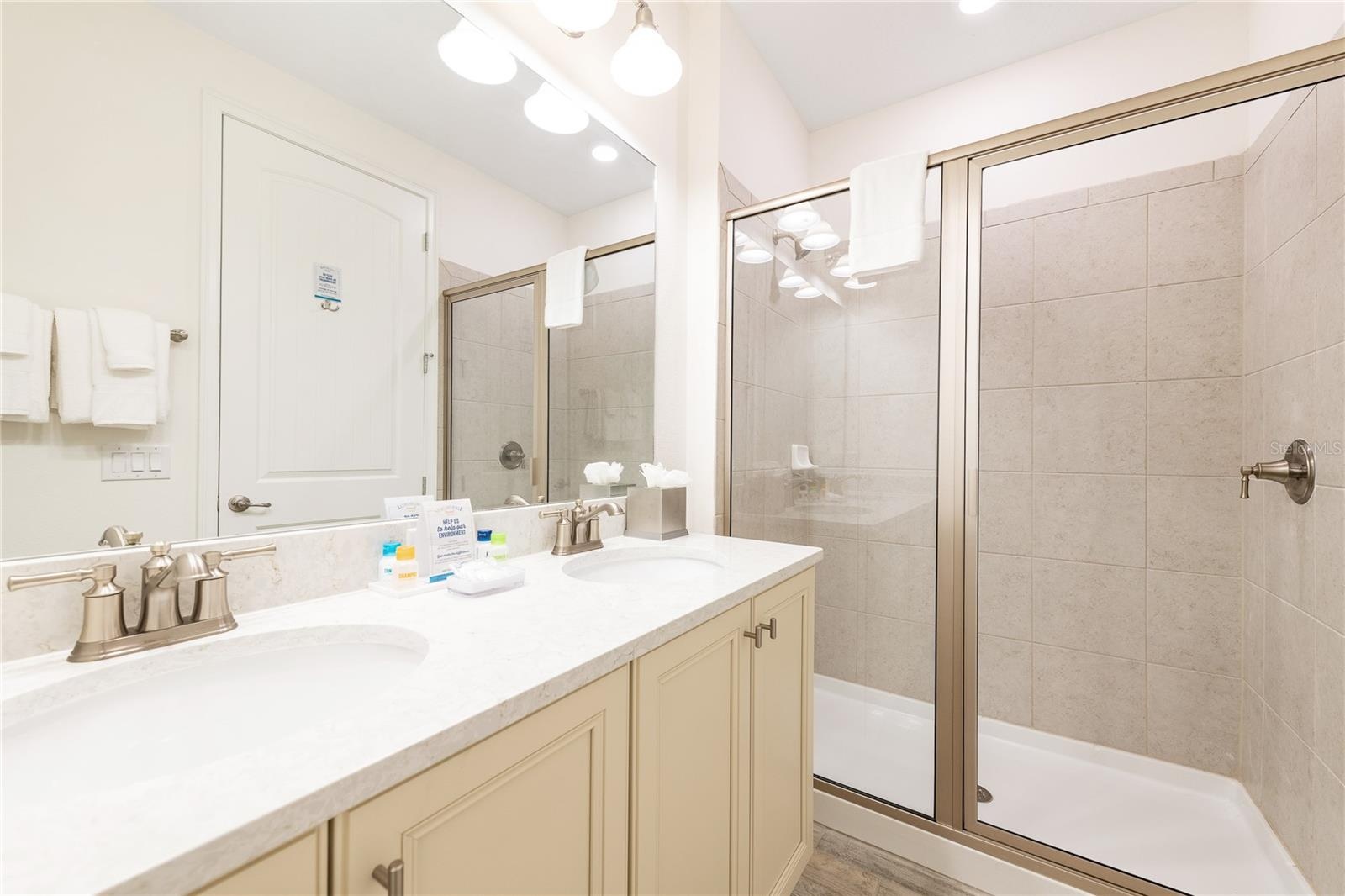 Primary bathroom with dual vanities and walk in shower in Kissimmee Florida resort home