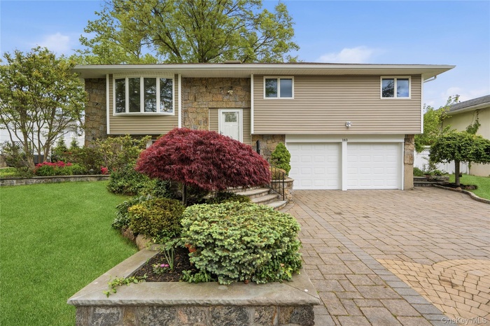 Hi-Ranch Home featuring stone and new siding with Paver Driveway