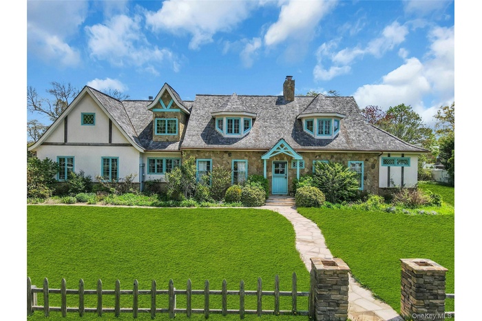 Stone and stucco exterior featuring a prominent teal front dutch door and complementary trim
