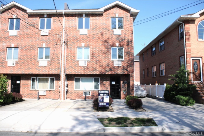 Three-story brick exterior featuring multiple windows with white trim