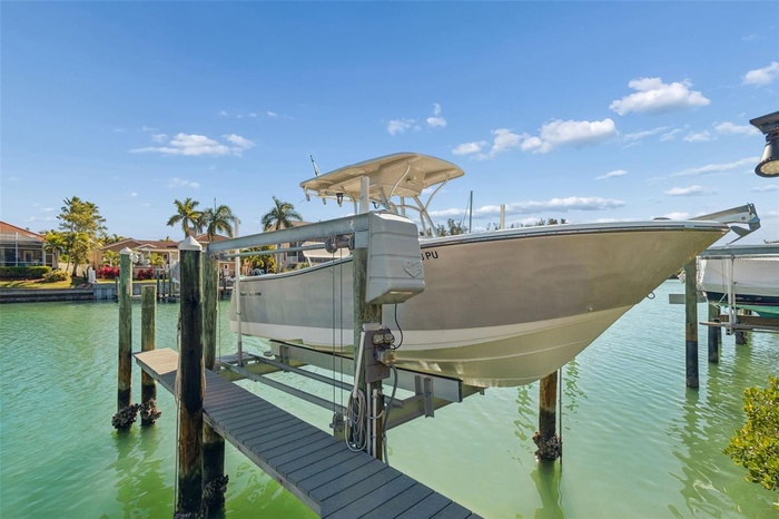 Deeded boat slip with 10,000-lb lift on a protected canal, offering quick access to open water — perfect for boating, fishing, and effortless waterfro