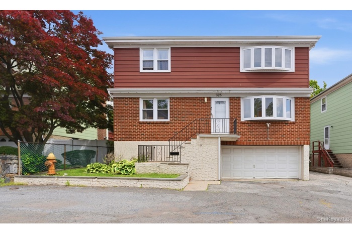 Two-story residence featuring a brick first level and red siding on the second level
