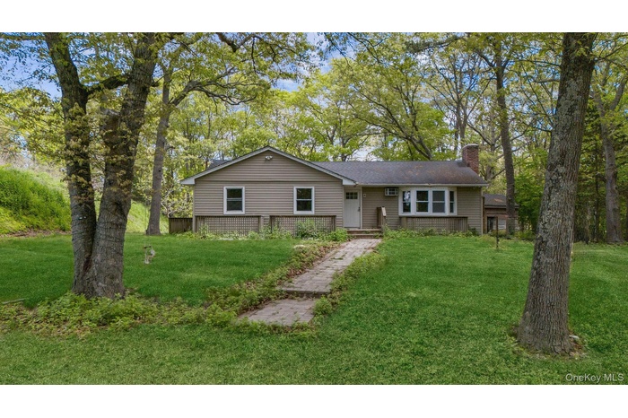 Ranch-style residence featuring neutral siding, a front entry door, and a bay window