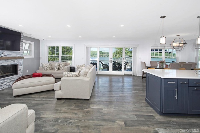The living room, dining room, & kitchen connect seamlessly, creating an inviting and open space for entertaining with spectacular views of the lake.