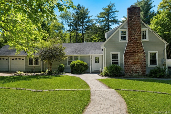 Ranch styled home with brick walkway, wrap around driveway & 2 car garage on 1 acre of land