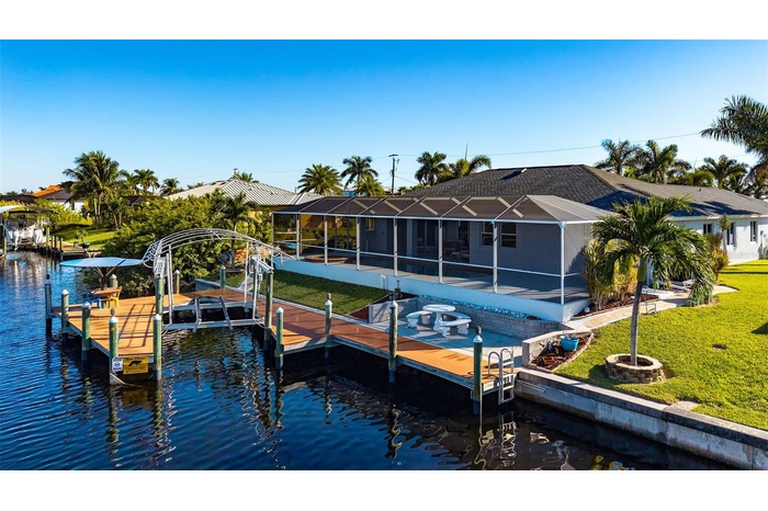 Canal view of deck, boat life, tiki hut, full lanai