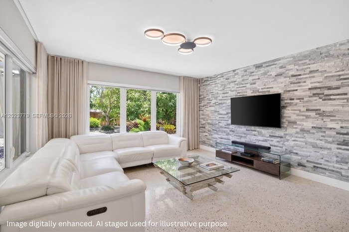 Inviting Family Room with Stacked Stone accent wall, original and restored and polished terrazzo floors and large impact windows overlooking the priva