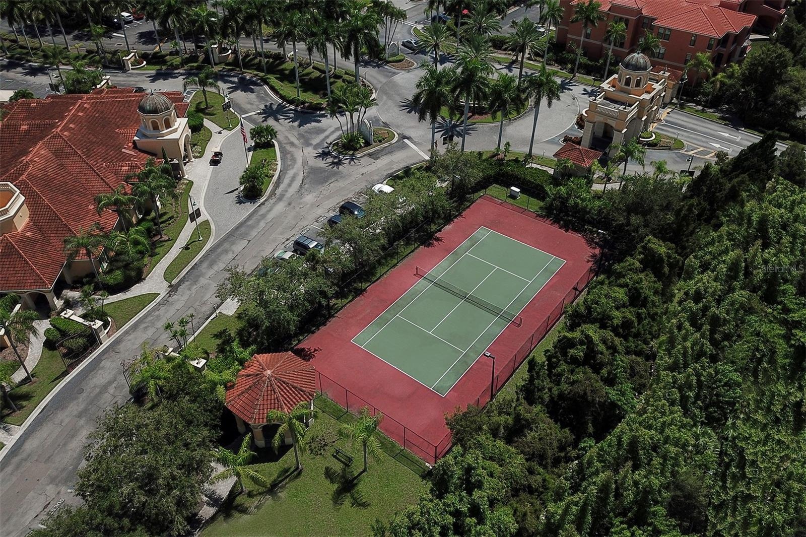 Aerial view of the tennis court and the Guardhouse to the right; Grand Bellagio clubhouse to the left