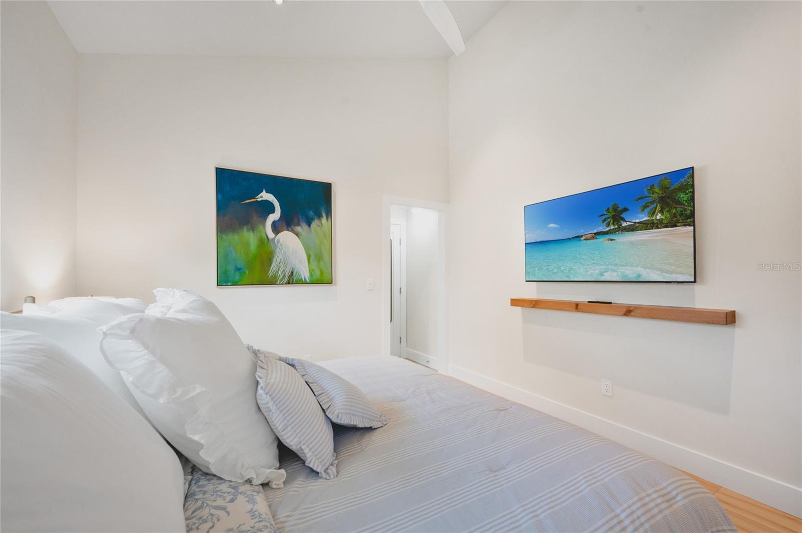 Guest bedroom with original artwork and flat screen TV
