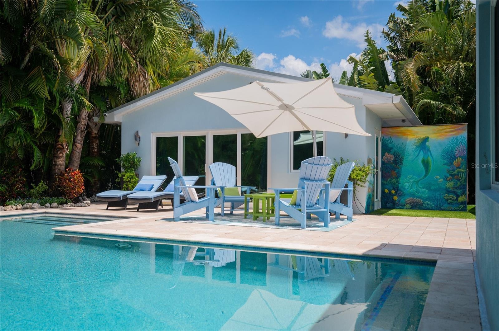 Enjoy outdoor lounging or a refreshing swim in the pool all surrounded by tropical landscape and a beautiful mural by Cheeta Ruis.
