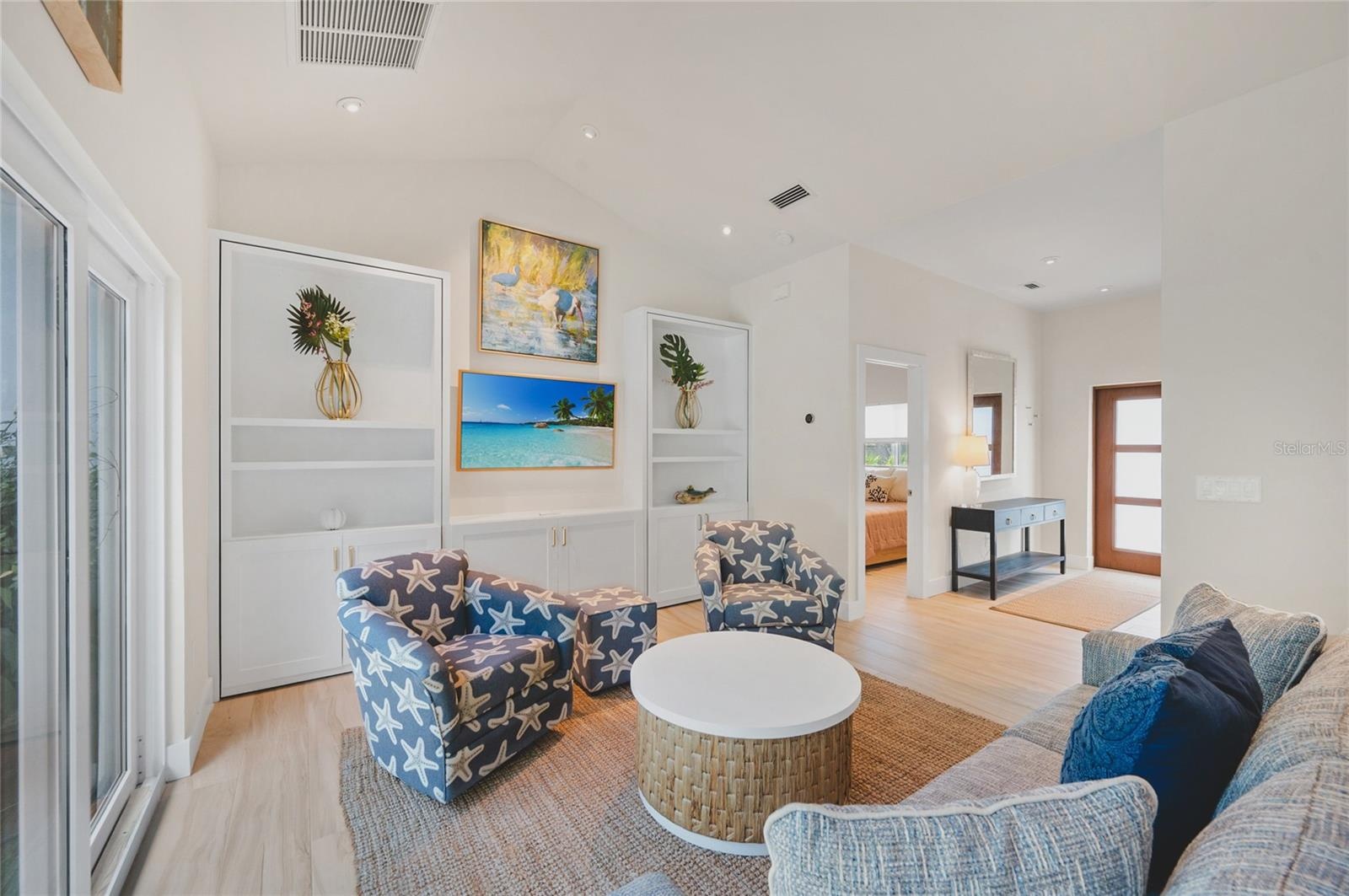 The living room has all new furnishings, a frameless TV and plenty of light from the sliders that go directly into the pool area.