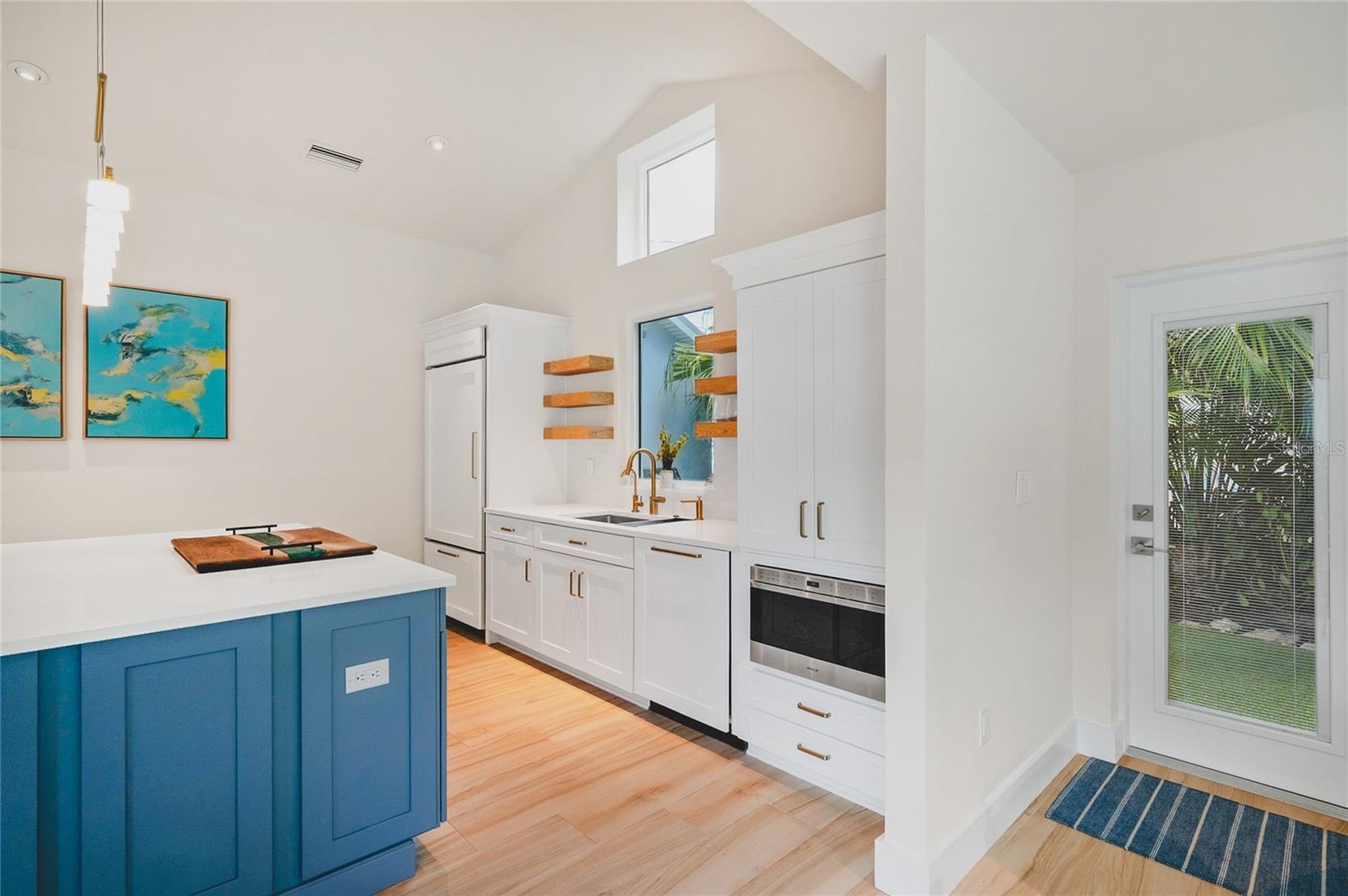 Just off the kitchen is a doorway to the side yard where you will find a barbecue area surrounded by tropical landscaping and turf.