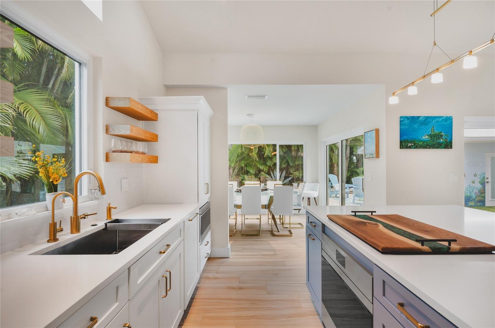 The home seamlessly flows from living to kitchen to dining all surrounded by windows and doors with tropical views.