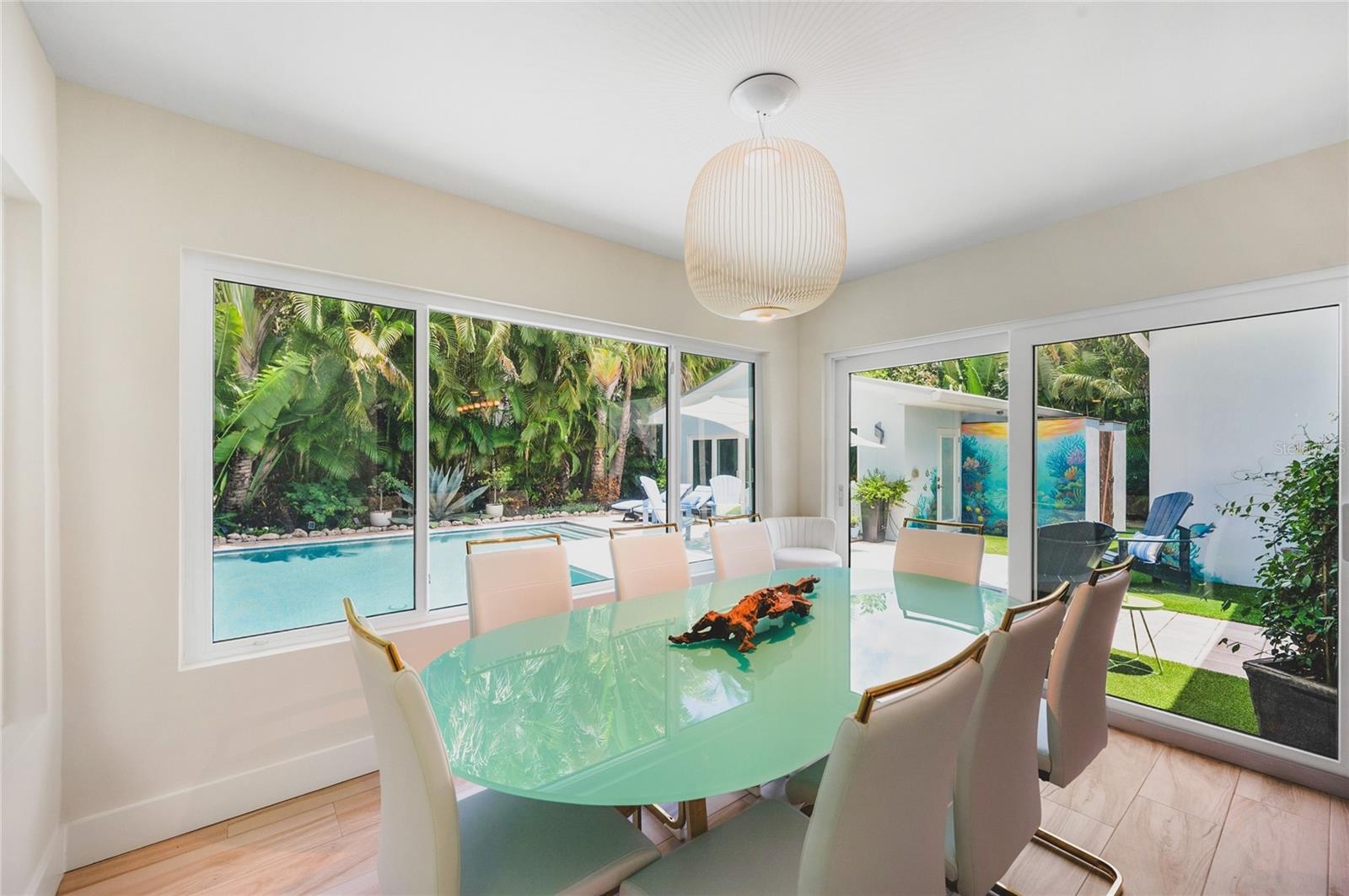 Enjoy dining with family and friends in this light and bright dining area with tropical pool views