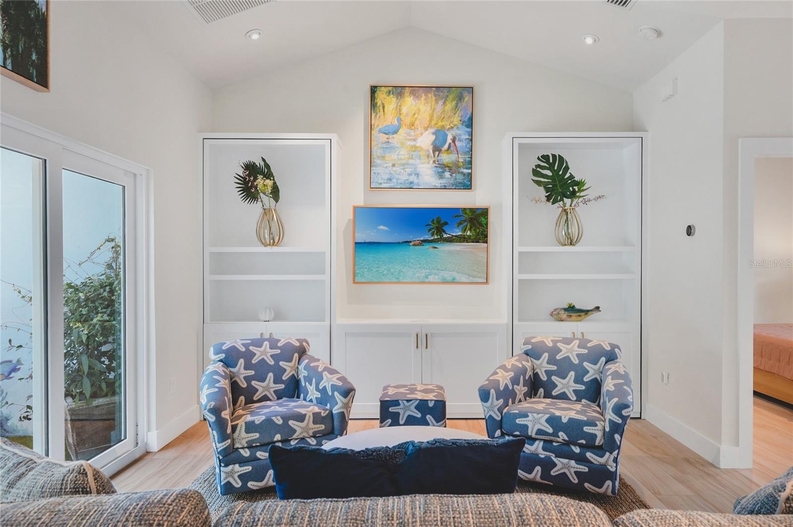 Living room showcasing the built in bookcases with the right bookcase being the hidden doorway to the primary suite