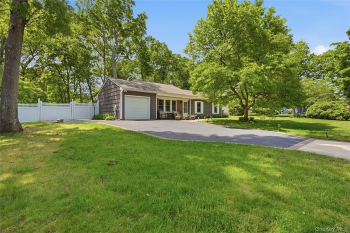 Ranch-style residence featuring cedar shake siding and a white garage door