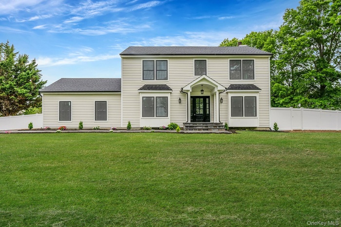 Two-story residence featuring new light-toned siding, a new dark shingle roof, and a prominent front entrance with double doors