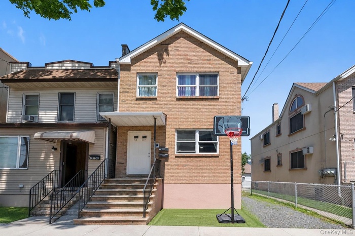 Two-story brick exterior featuring multiple windows and a covered entryway