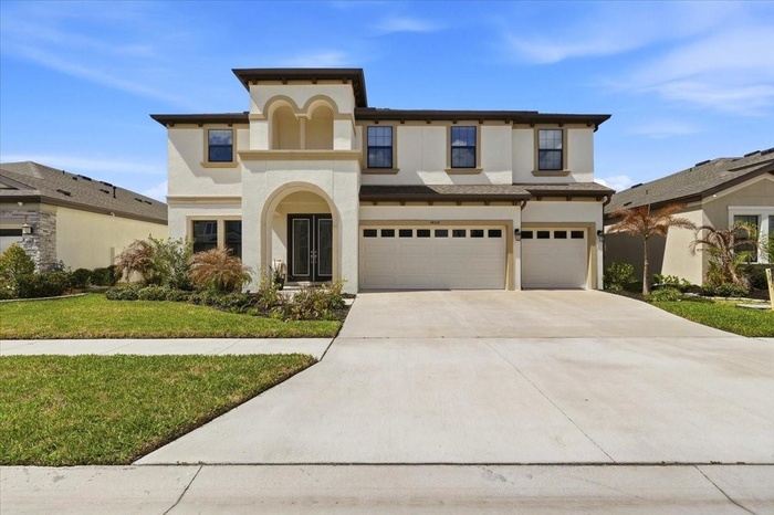 Stunning Mediterranean-style luxury home in Lithia FL | Two-story 4-bed move-in ready residence with 3-car garage, paver driveway, and lush tropical l