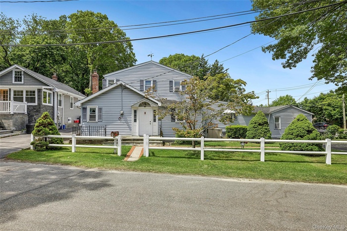 Unit #1 Main house with 3 bedrooms & 1.5 baths.  Two-story residence featuring light gray vinyl siding, white trim, and a white front door with glass 