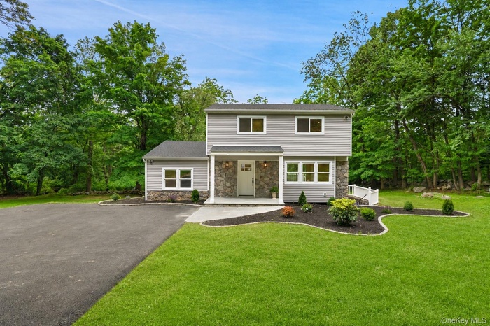 Contemporary home featuring grey siding and stone veneer accents