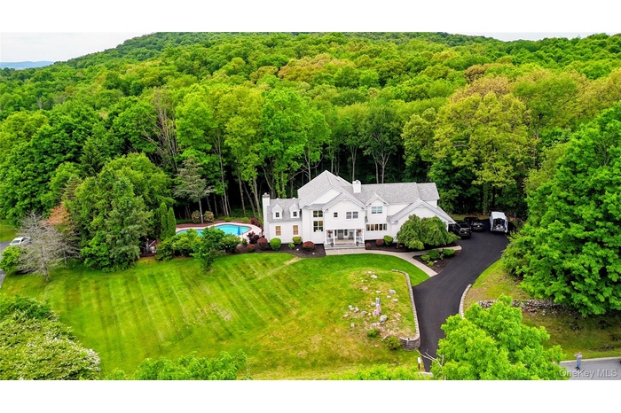 Expansive white multi-story residence with a multi-gabled roof and multiple chimneys