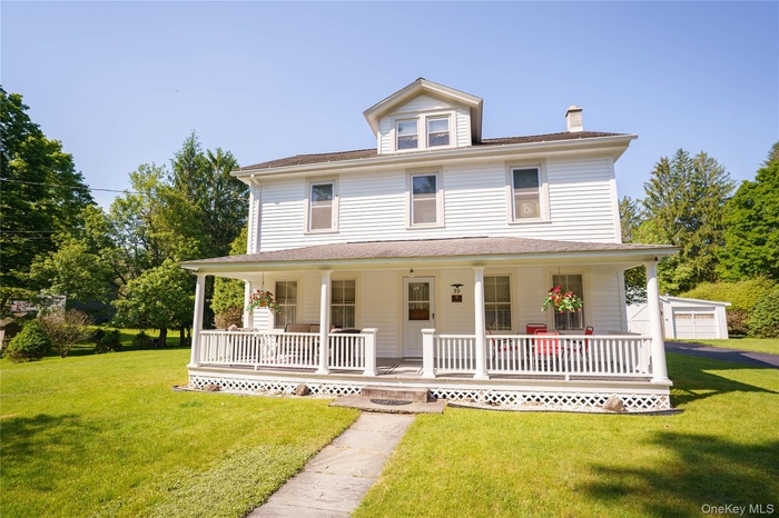 Traditional white-sided residence featuring a full-width covered porch with white columns and railing