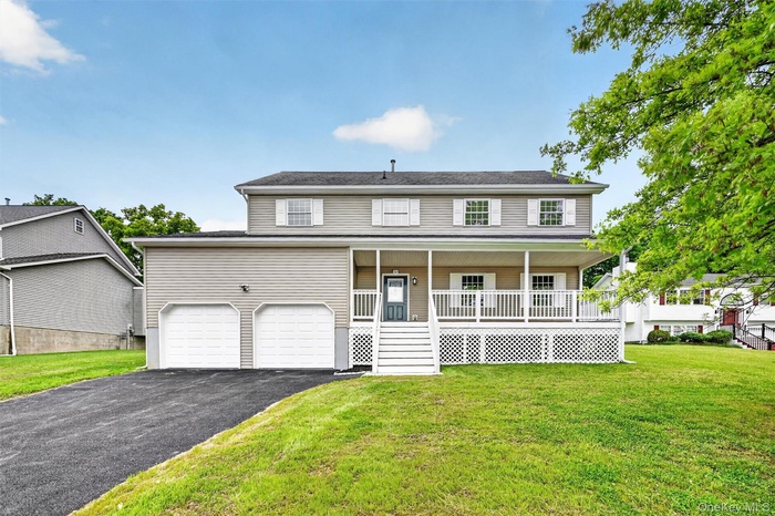 Two-story residence featuring light gray siding and a covered front porch with white railings