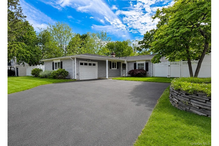 Ranch-style residence featuring horizontal siding and dark window shutters