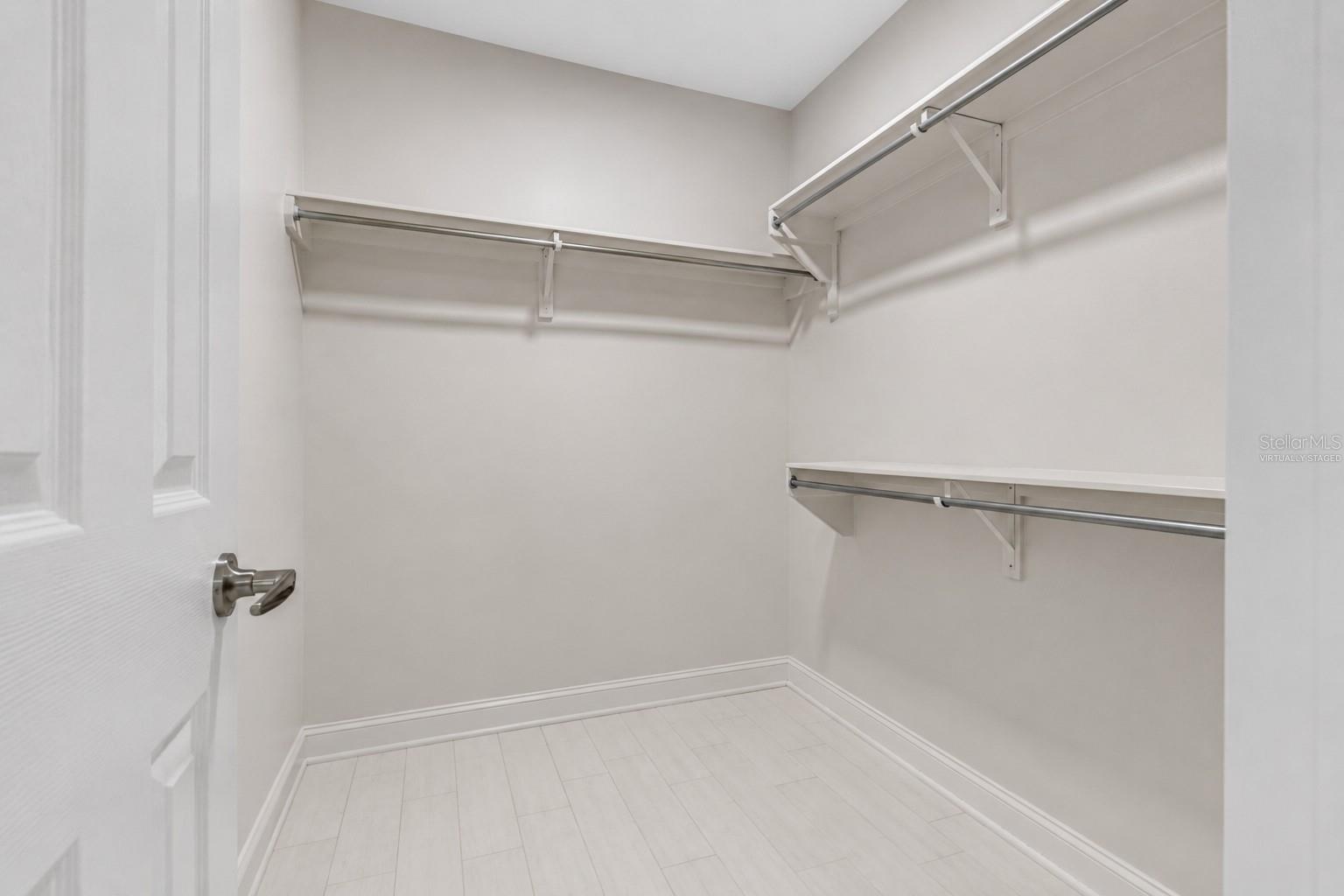 Virtually staged walk- in closet in primary bedroom