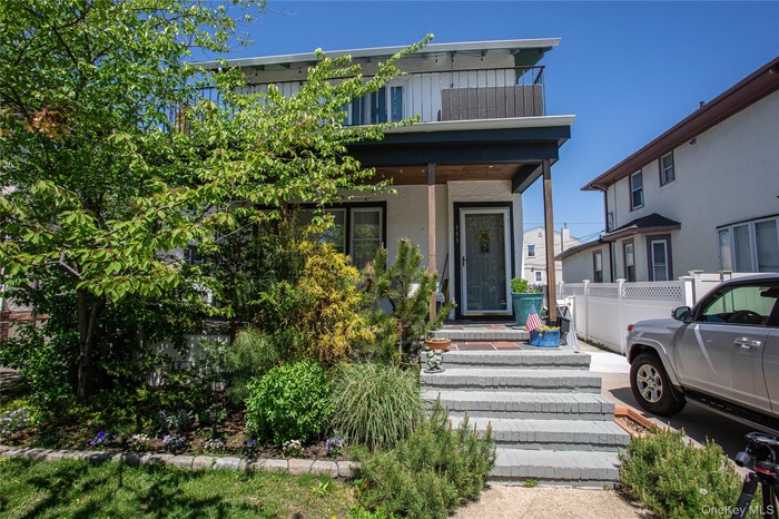 View of front facade with fence and stucco siding
