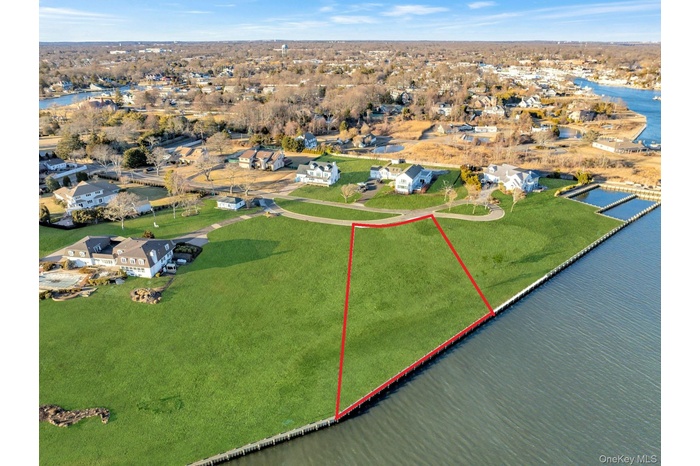 Aerial view of residential area with property parcel outlined and a nearby body of water