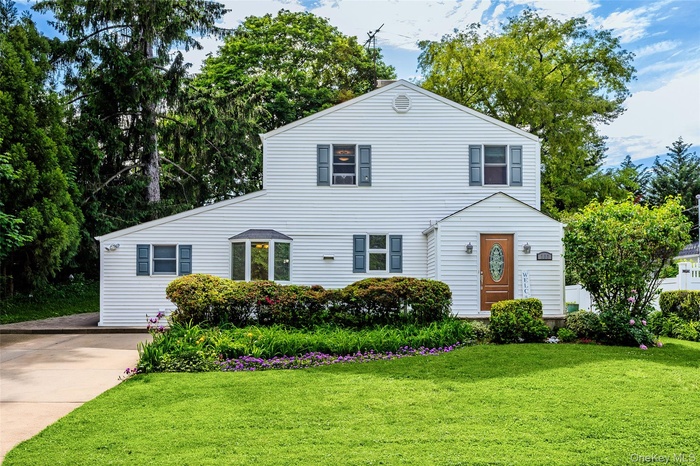 Two-story colonial featuring white siding on large lot