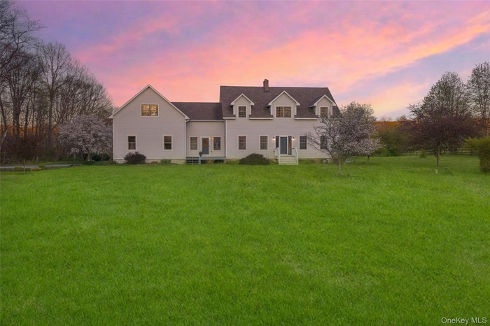 Twilight exterior showcasing the home’s expansive open grounds and peaceful Hudson Valley setting