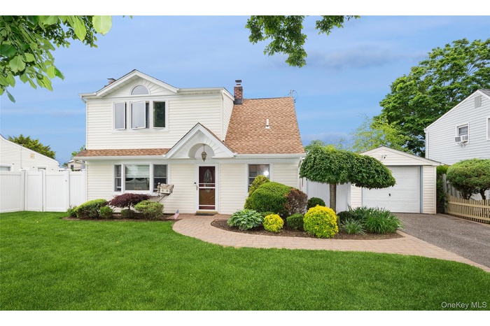 Two-story residence featuring white siding and a brown shingle roof