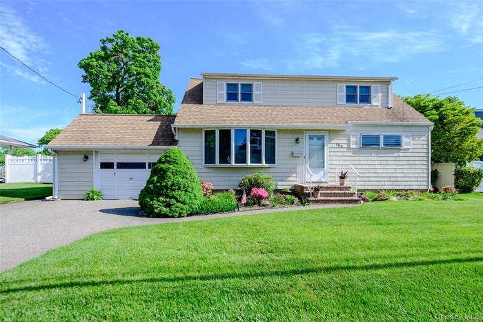 Cape Cod style home with one car garage, private driveway and lush front lawn.