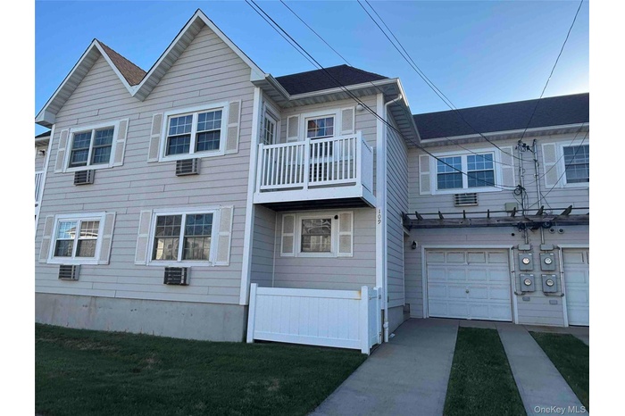 Top floor condo residence featuring light-colored siding and a gabled roofline