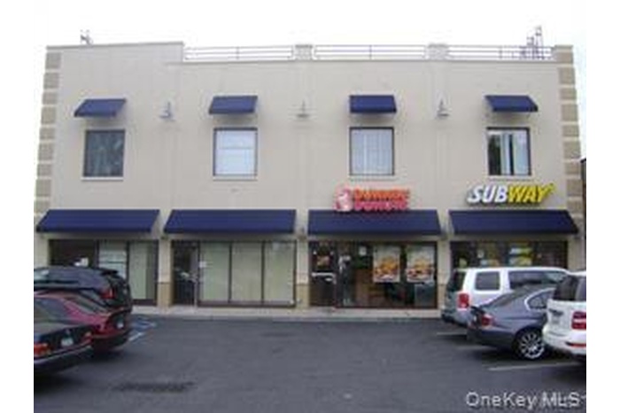 View of building exterior with uncovered parking