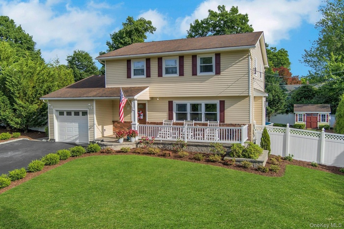 Two-story residence with light-colored siding and dark shutters