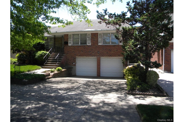 Brick exterior with white shutters. 2 car garage