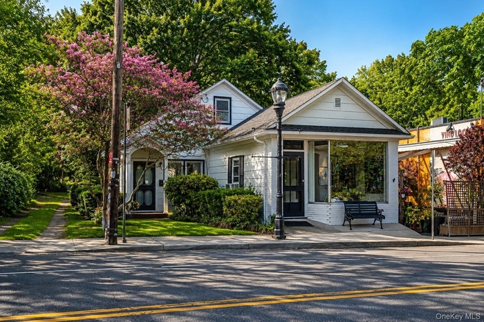 White exterior with black trim and a prominent storefront window