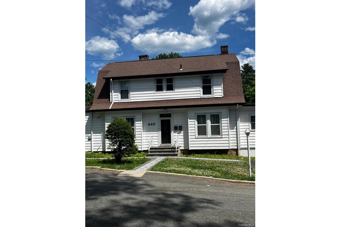 White clapboard siding exterior with a gambrel roof