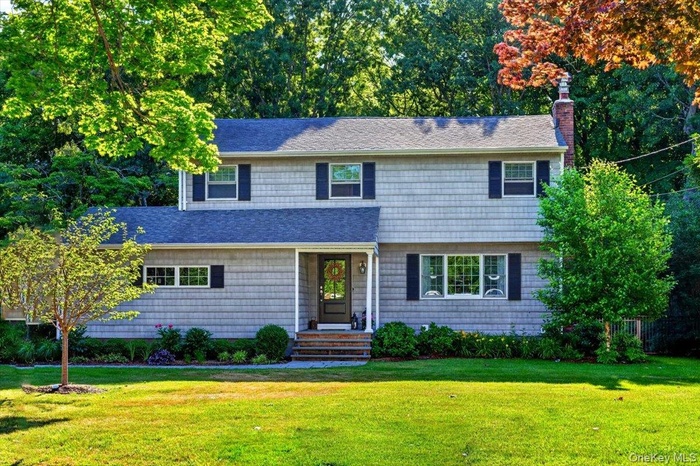 Two-story residence featuring horizontal siding, a dark roof, and contrasting shutters